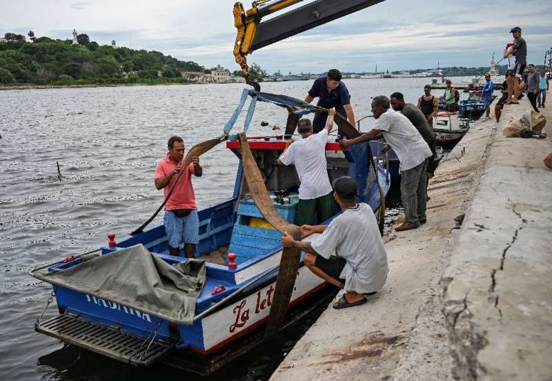 People pull small boats out of Havana Bay on Monday before Hurricane Ian hit Cuba