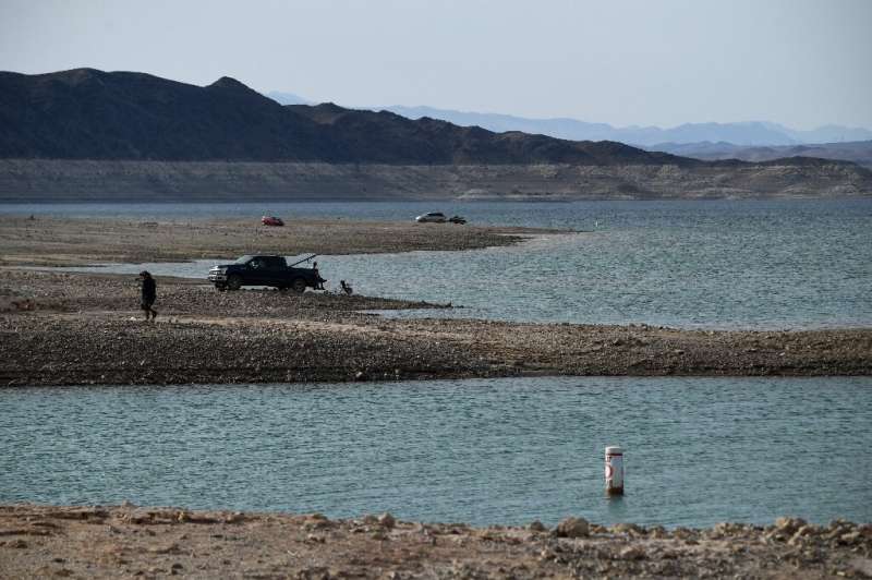 People recreate on the shore during low water levels due to the western drought at the Lake Mead Marina on the Colorado River in