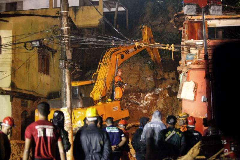 Rescue workers are seen at the site of a massacre where a mother and her six children were killed in Paraty, Rio de Jane.