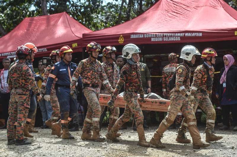 Rescue workers scoured muddy terrain for survivors and bodies as the death toll from a landslide at a Malaysian campsite rose to