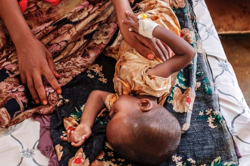 Small comfort: Mother Rukiyo Adan Mahad cuddles her sick daughter Samyia at the nutrition unit of the Gode General Hospital