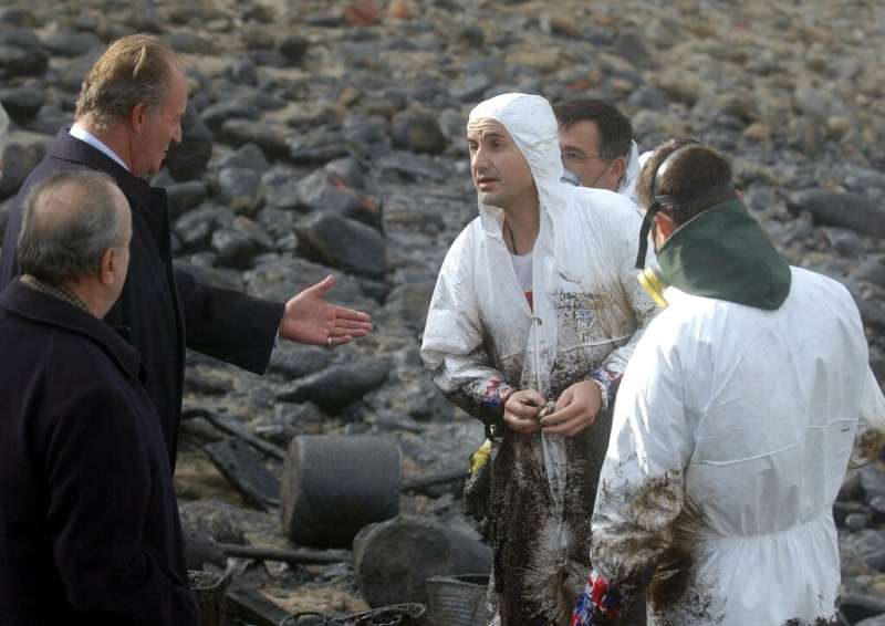 Spain's former king Juan Carlos talks to volunteers helping clean up the 'Prestige' oil spill at Muxia in 2002