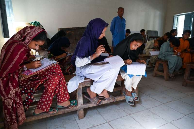 Students sit for an exam during a power cut at a government school