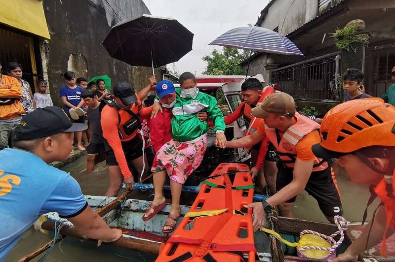 The Philippine Coast Guard and police rescued people from their homes in the flooded town of Abuyog in Leyte province