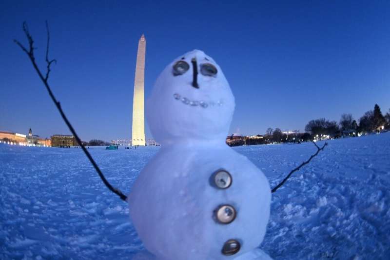 The Washington Monument is seen on the snow-covered National Mall in Washington, DC at sunset on January 3, 2022