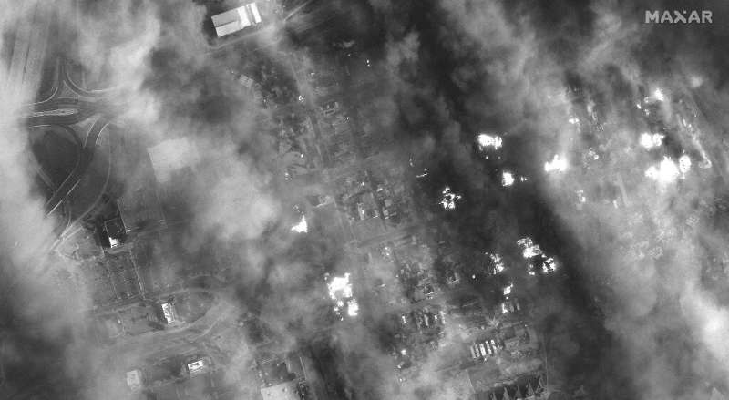 This handout black and white WorldView-1 satellite image released by Maxar Technologies shows homes and shopping center engulfed