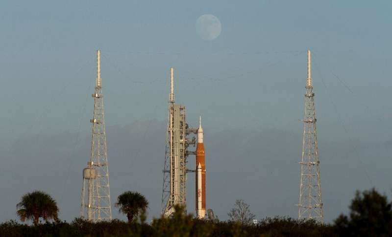 This NASA handout photo shows the Moon as it rises behind NASA's Space Launch System (SLS) rocket