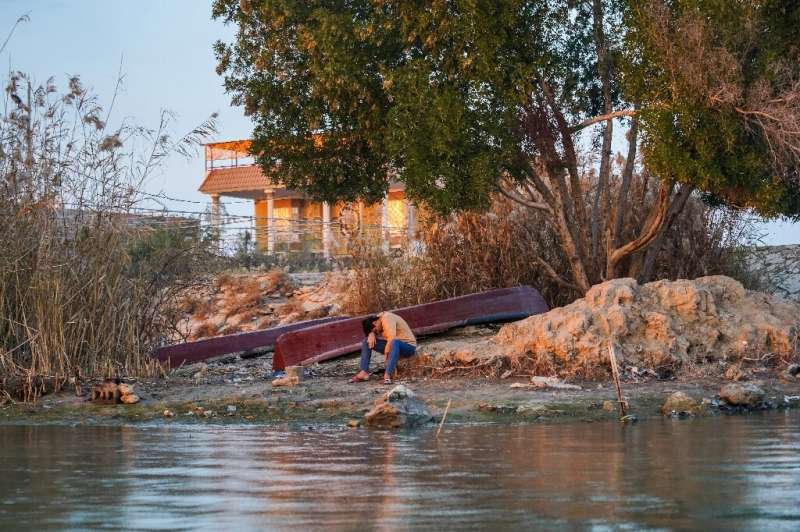 Threatened Eden: a young man bows his head on the banks of the Shatt al-Arab in southern Iraq
