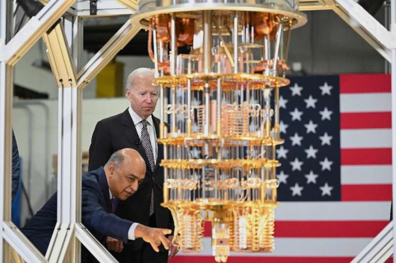 US President Joe Biden listens to IBM CEO Arvind Krishna as he tours the IBM facility in Poughkeepsie, New York