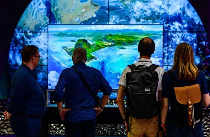 Visitors contemplate an 8K TV at the stand of South Korean consumer goods giant LG at the tech fair -- motto this year &quot;ene