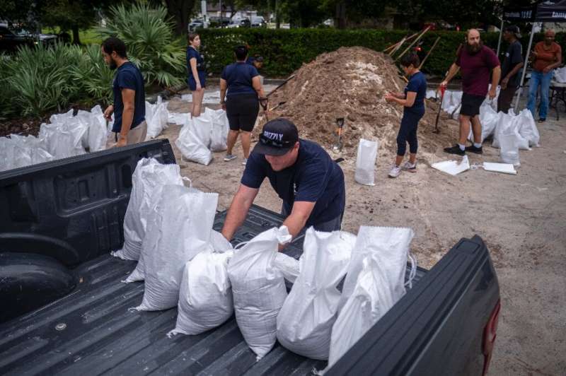 Volunteers and city employees were scrambling to fill and load sandbags ahead of the arrival of Hurricane Ian, which US forecast