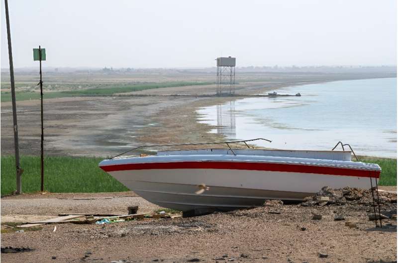 A boat is grounded by the receding shoreline of Iraq's Lake Habbaniyah, affected by a severe four-year drought
