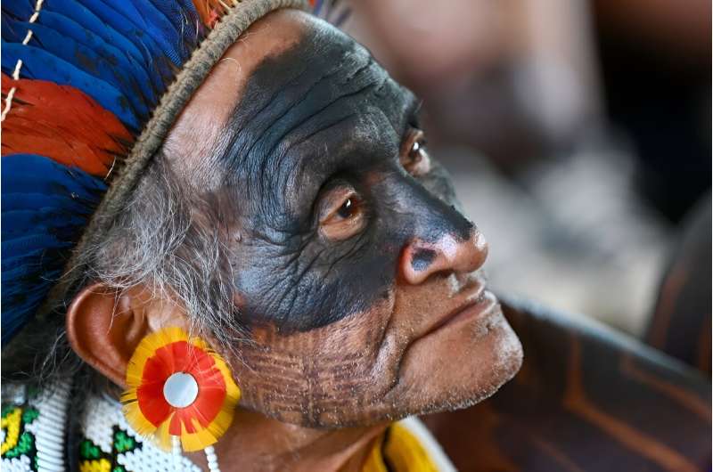 A Brazilian Indigenous man follows the trial at the Supreme Court on whether to restrict native peoples' rights to claim their ancestral lands on a screen outside the facility in Brasilia on September 21, 2023.