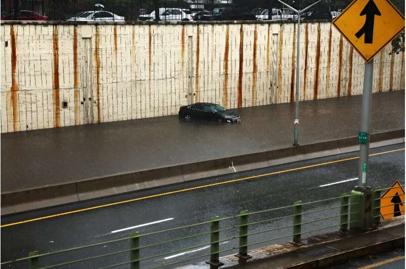 A car stranded on a flooded road in Brooklyn after heavy rains inundated New York City and the surrounding areas