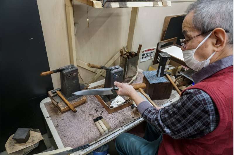 A craftsman attaches a handle to a 'gyuto', the Japanese equivalent to a western chef's knife, at Yamawaki Cutlery in Osaka prefecture