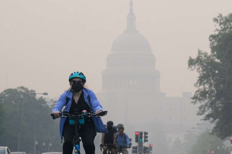 A cyclist rides under a blanket of haze partially obscuring the US Capitol in Washington, DC, on June 8, 2023