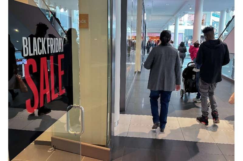A family walks past a store advertising a Black Friday sale near Pentagon City Mall in Arlington, Virginia