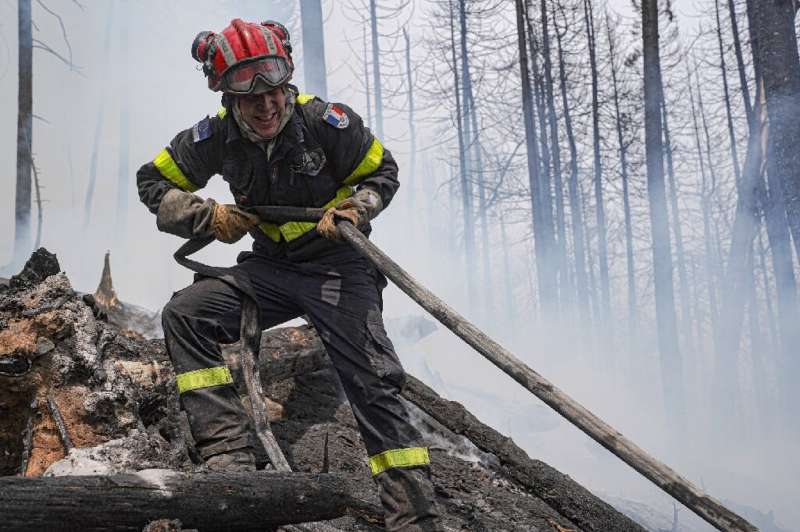 A French firefighter battles a blaze at Lac Larouche in Canada's Quebec Province in late June