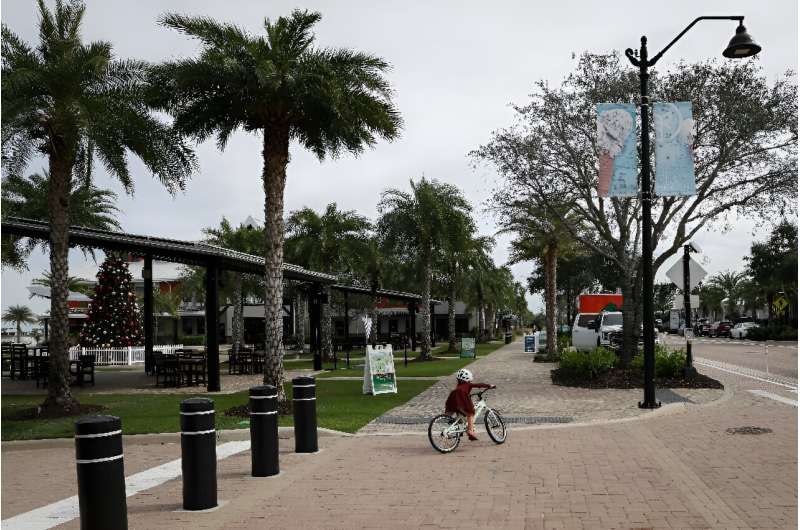 A girl rides a bicycle at Founder's Square in Babcock Ranch, Florida