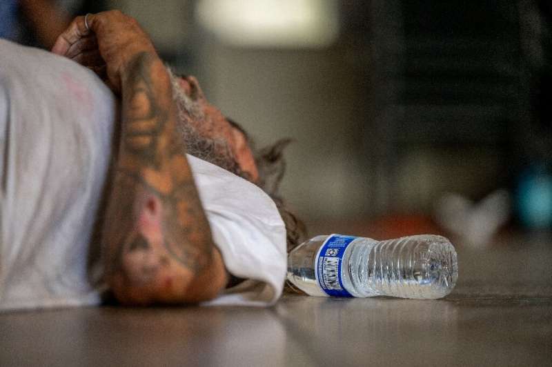 A man exhausted by the scorching heat takes a rest at a Phoenix church in Arizona in July 2023