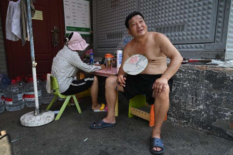 A man arranges himself in a Beijing alley as the Chinese capital bakes under a record-breaking run of high temperatures
