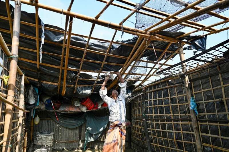 A man fixes his house's roof which was destroyed by Cyclone Mocha, on Shahpori island on the outskirts of Teknaf, Bangladesh