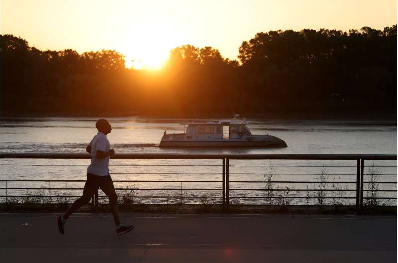 A man jogs along the docks at sunrise to avoid the heat, in Bordeaux, southwestern France.