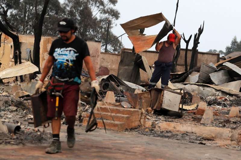 A man removes debris from a house in Tome, in southern Chile, on February 4, 2023 after scores of fires raged through the area