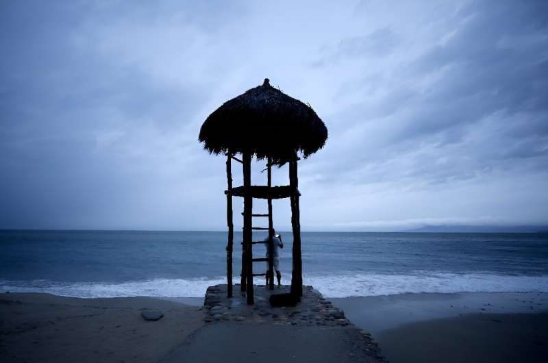 A man takes pictures under a lifeguard hut in Mexico's Puerto Vallarta