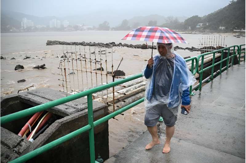 A man walks on a bridge over a swollen river on Lantau Island in Hong