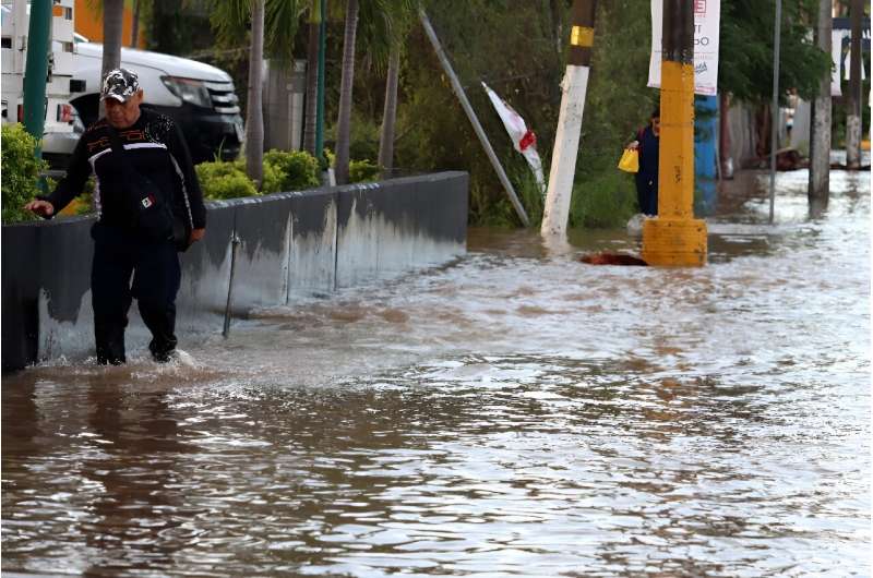 A man walks through a flooded street after Hurricane Lidia drenched the Mexican seaside city of Puerto Vallarta