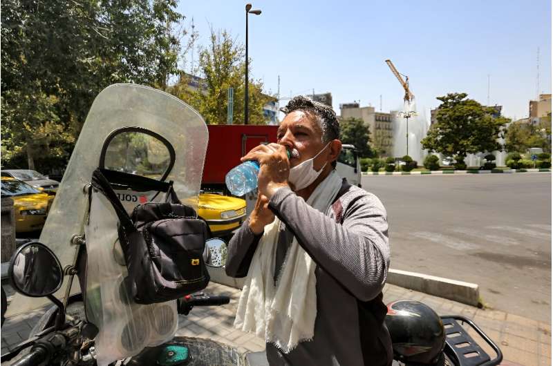 A motorcyclist takes a break in the heat of Tehran on July 11, 2023