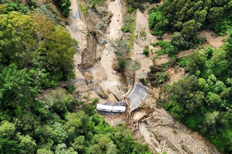 A New Zealand Defence Force photo shows a truck stranded on a road covered with debris near Wairoa on the east coast of New Zeal