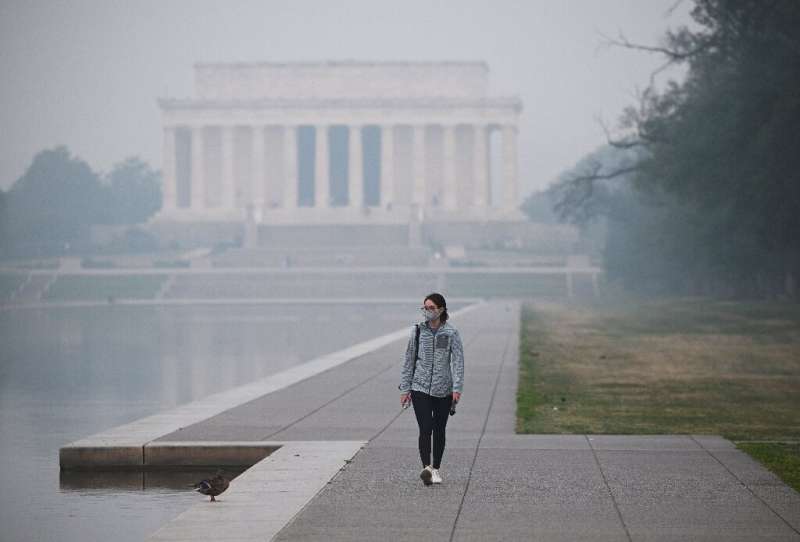 A person walks near the Lincoln Memorial under a blanket of haze in Washington on June 8, 2023