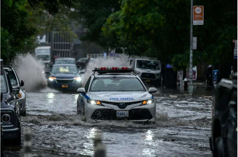 A police car pushes through flooded streets in New York