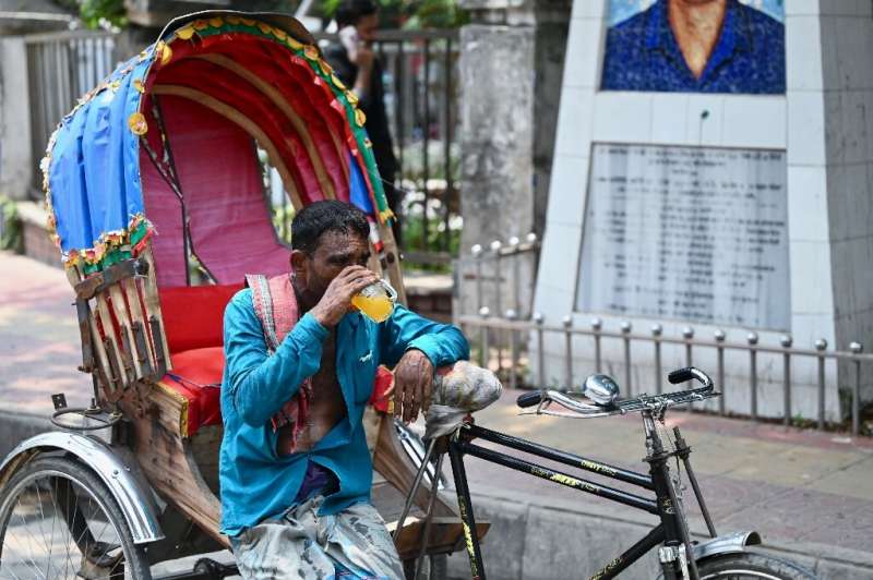 A rickshaw puller quenches his thirst with a juice during a heatwave in Dhaka, Bangladesh on June 6, 2023