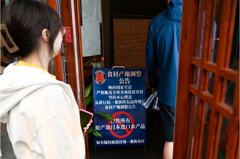 A sign in Beijing tells customers that the 'sale of all fish products imported from Japan' has been suspended