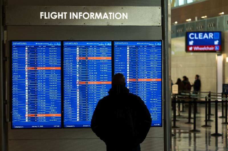 A traveler looks at a display listing cancelled and delayed flights at Ronald Reagan National Airport in Virginia on January 11,