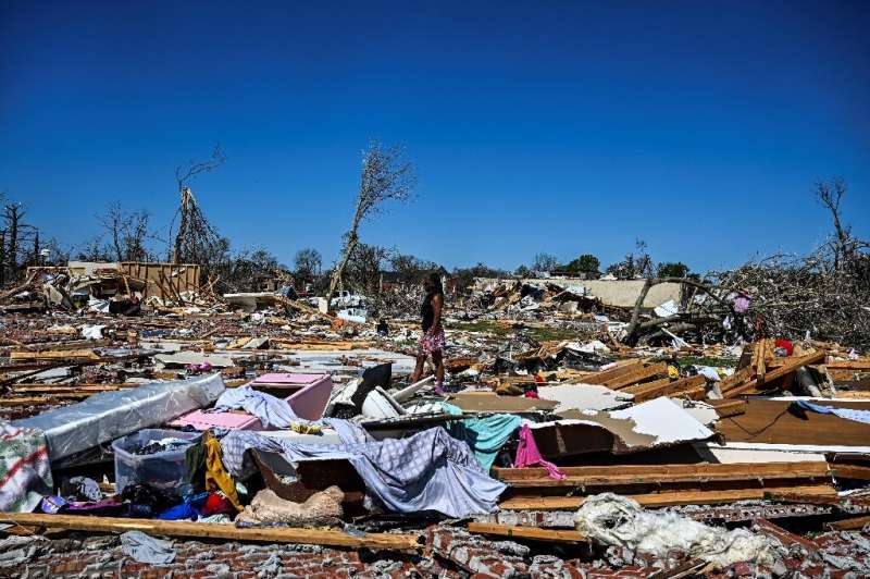 Женщина в Роллинг-Форк, штат Миссисипи, идет среди развалин домов, разрушенных мощным торнадо, опустошившим часть города.