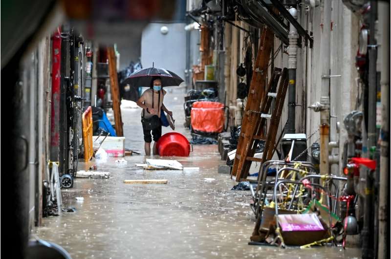 A woman walks in a flooded back alley in Hong Kong