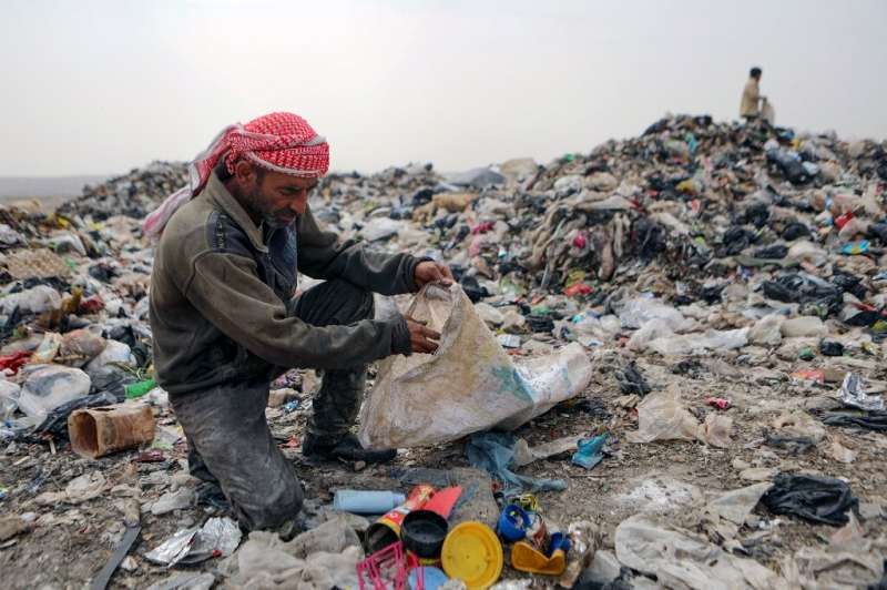 Abu Mohammed sifts through rubbish at a dump near the village of Hazreh
