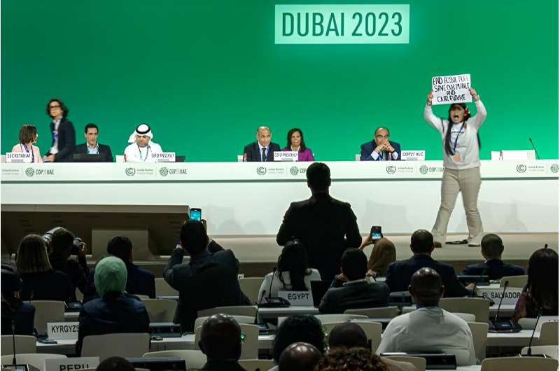 An activist held a sign against fossil fuels at a COP28 event