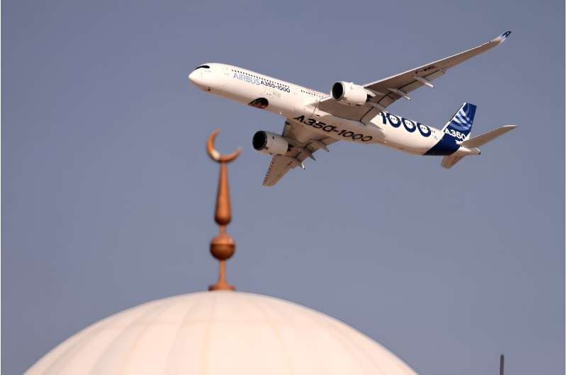An Airbus A350-1000 aircraft flies above a mosque during the ongoing Dubai Airshow
