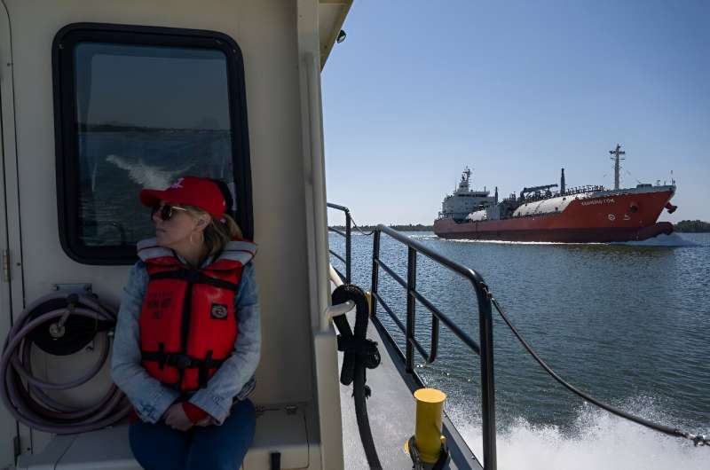 An Army Corps of Engineers employee looks on as a cargo ship navigates the Mississippi River -- the Corps is responsible for keeping US waterways navigable