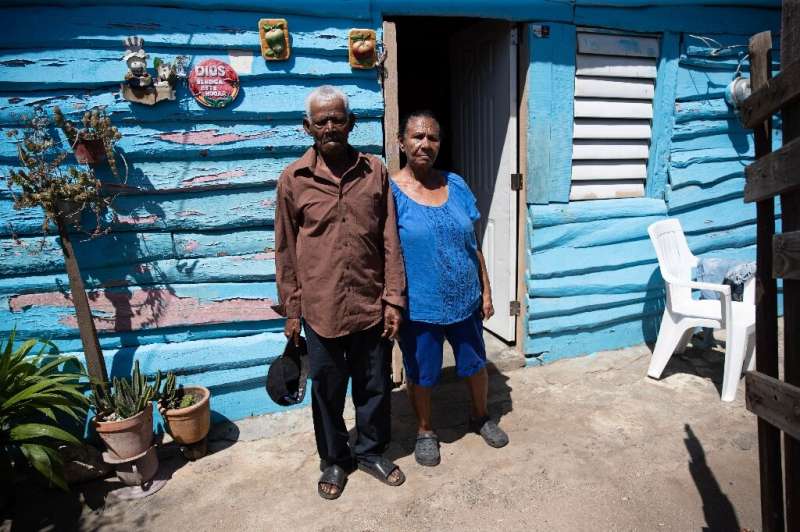 Ana María Luciano and Bartolo Franco pose in front of their house which is going to be demolished to make way for the anti-migra