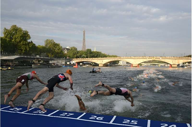 Athletes dive into the Seine River on Friday for the men's 2023 World Triathlon pre-Olympic test event