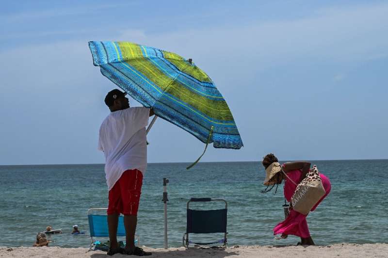 Beachgoers sunbathe during during an intense heat wave in Miami Beach on July 16, 2023