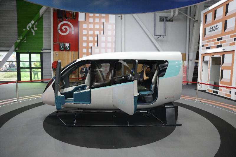 Brazil's Embraer and its subsidiary Eve Air Mobility say they will begin manufacturing electric flying taxis, a model cabin of w