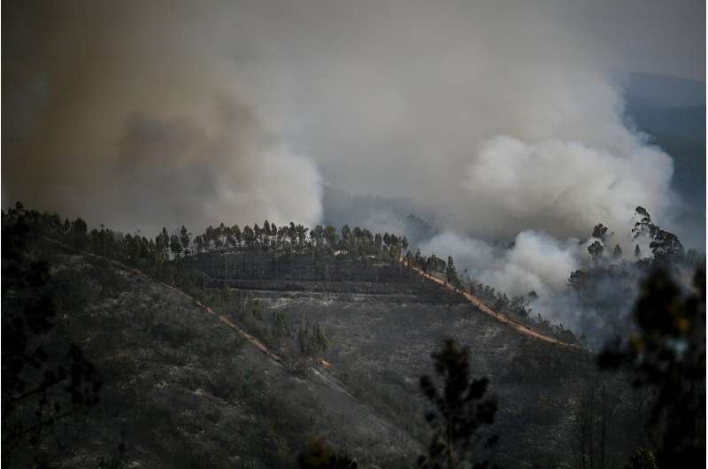 Columns of smoke rise from wildfire in Odeceixe, southern Portugal, as temperatures soar there and in neighbouring Spain