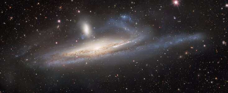 Dark energy camera captures galaxies in lopsided tug of war, a prelude to merger
